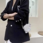 "Sac à main argenté Cora porté sur l'épaule par une femme - Style et fonctionnalité réunis"