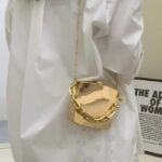 "Sac-a-main-dore-Cora-femme-portant-epaule"