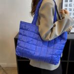 Rebeca sac à main fourre-tout matelassé bleu - Femme portant le sac sur l'épaule.