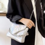 Femmes élégantes portant le sac à main blanc Cassie sur l'épaule - Un accessoire raffiné de chez Izamel.