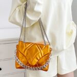 Femmes portant le sac à main orange Cassie - Élégance en mouvement avec le style Izamel.