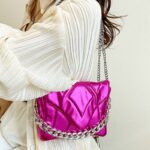 Femmes élégantes portant le sac à main rose Cassie sur l'épaule - Un accessoire fleuri de chez Izamel.