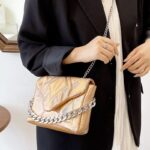 Femmes décontractées portant le sac à main saumon Cassie sur l'épaule - Un accessoire tendance de chez Izamel.