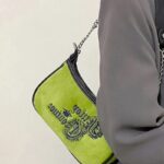 Manel : Sac à main porté à l'épaule par une femme - élégance en mouvement.