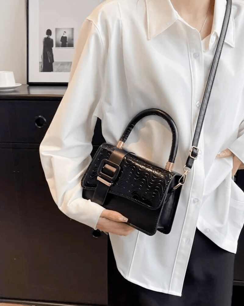 Femme élégante tenant fièrement le sac à main Gloria noir, un accessoire incontournable pour un style sophistiqué.