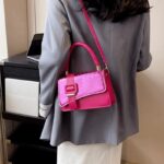 Femme chic portant fièrement le sac à main Gloria rose, une touche de charme pour un style affirmé.