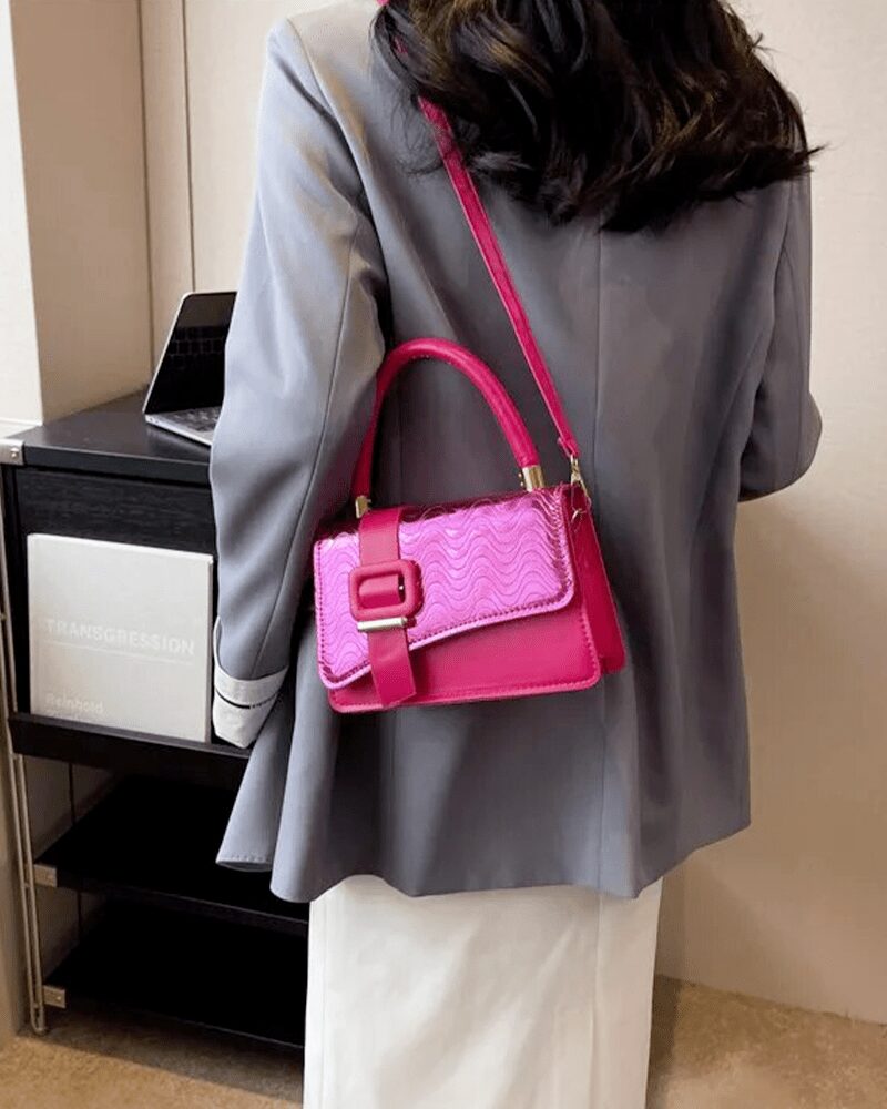 Femme chic portant fièrement le sac à main Gloria rose, une touche de charme pour un style affirmé.