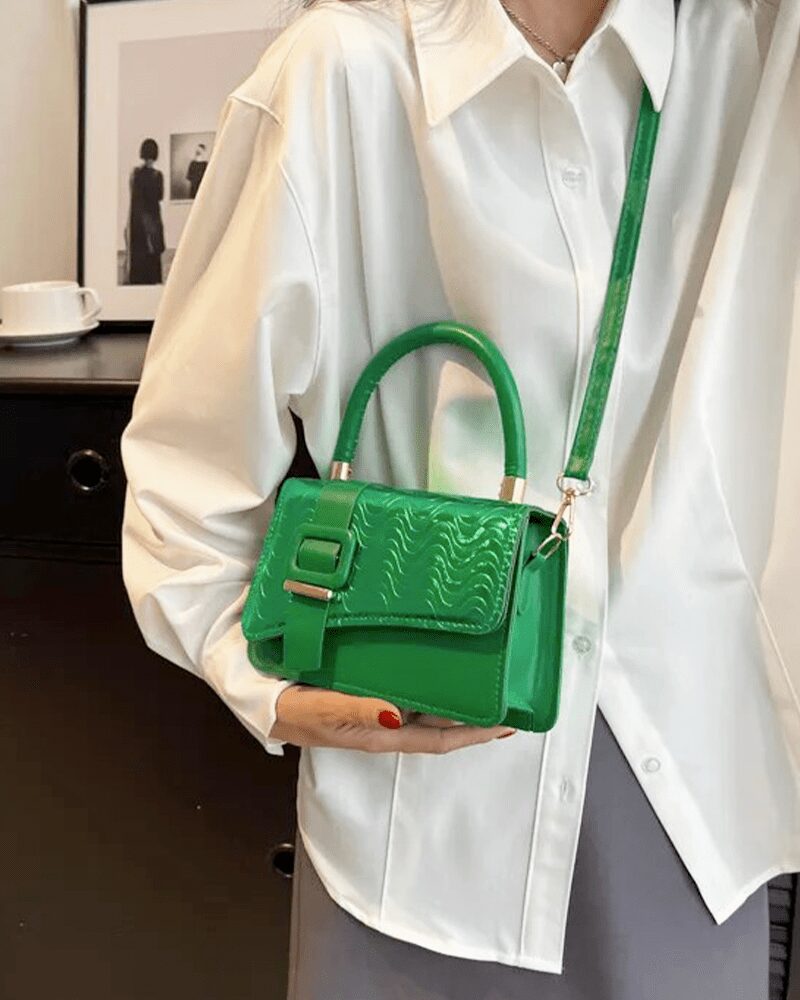 Femme tenant fièrement le sac à main Gloria vert, un accessoire chic pour un style vibrant.
