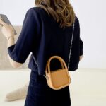 Affirmez votre style avec le sac à main orange Shay, une déclaration de mode vibrante portée avec élégance par les femmes de la boutique Izamel.