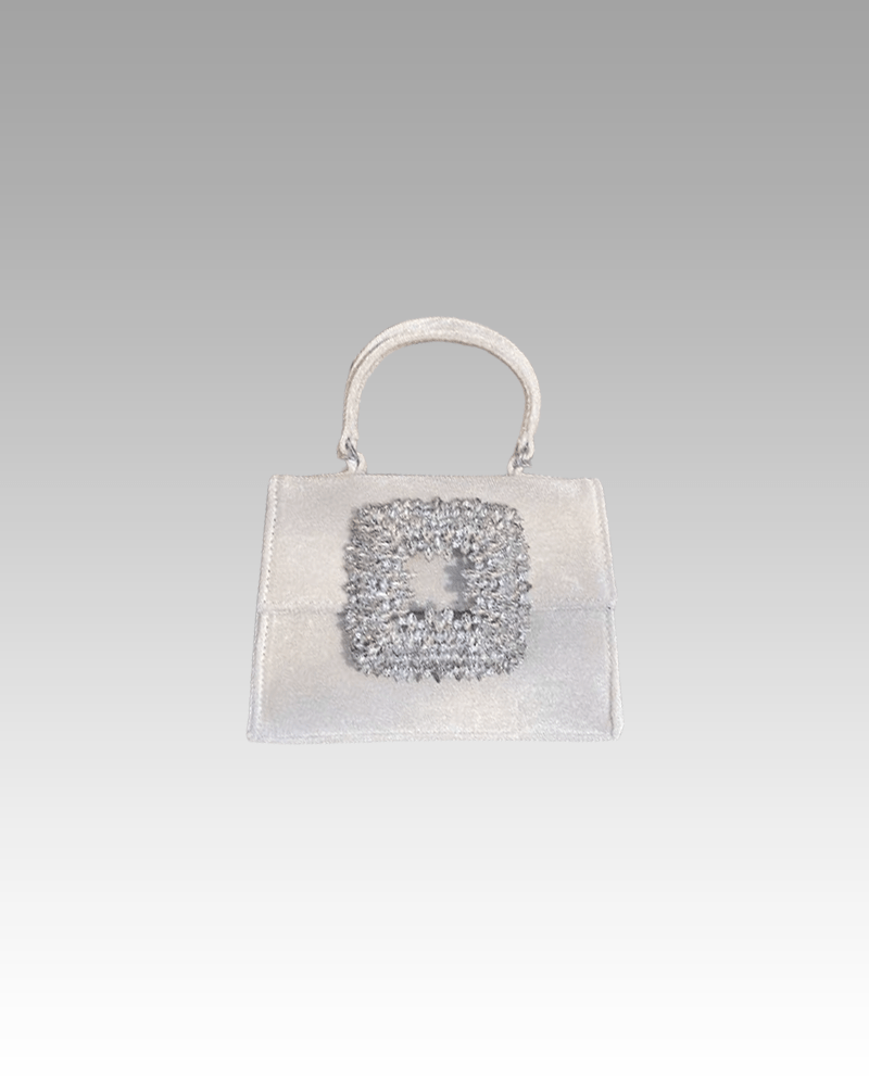 Élégance pure à Izamel : Découvrez le sac à main Elise en velours blanc, orné de strass scintillants, capturé dans l'ambiance raffinée de la boutique Izamel.