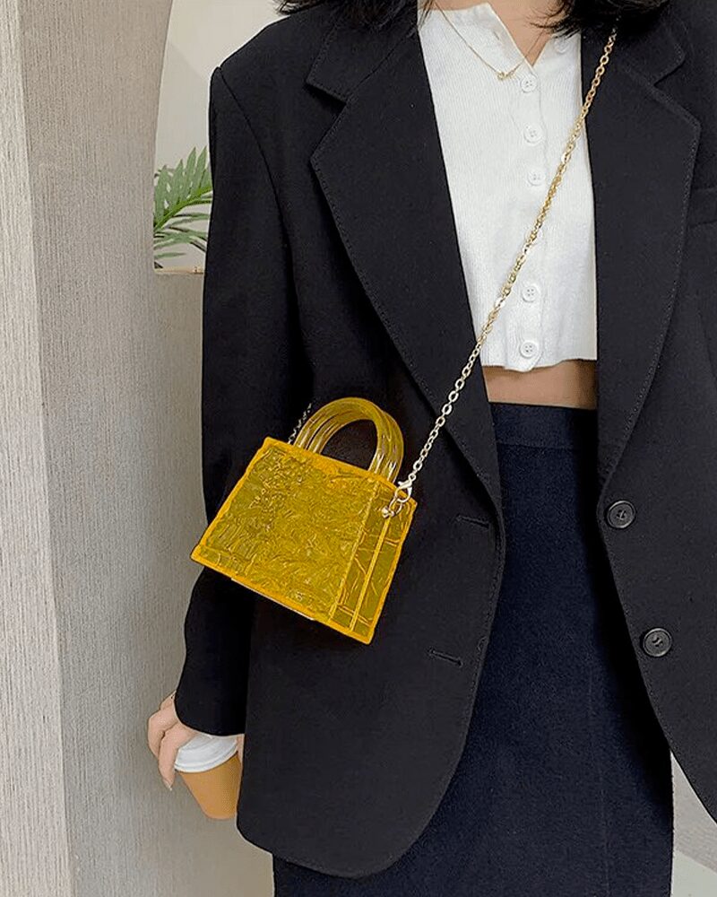 Femme au style dynamique avec le sac à main Megan orange craquelé en bandoulière, une déclaration audacieuse.