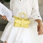 Femme élégante portant le sac à main Jasmine en similicuir jaune - Accessoire de mode Izamel.