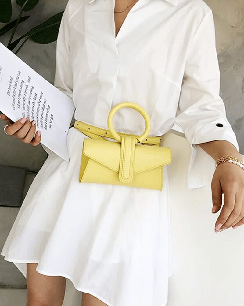 Femme élégante portant le sac à main Jasmine en similicuir jaune - Accessoire de mode Izamel.
