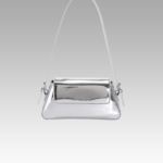 Explorez l'élégance scintillante avec le sac à main Molly en vernis argenté, un choix raffiné porté épaule pour sublimer votre style. Exclusivement chez Izamel.