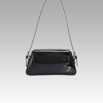 Découvrez le sac à main Molly, un accessoire de mode incontournable en vernis noir, idéal pour un porté épaule stylé. Disponible dans la boutique Izamel.