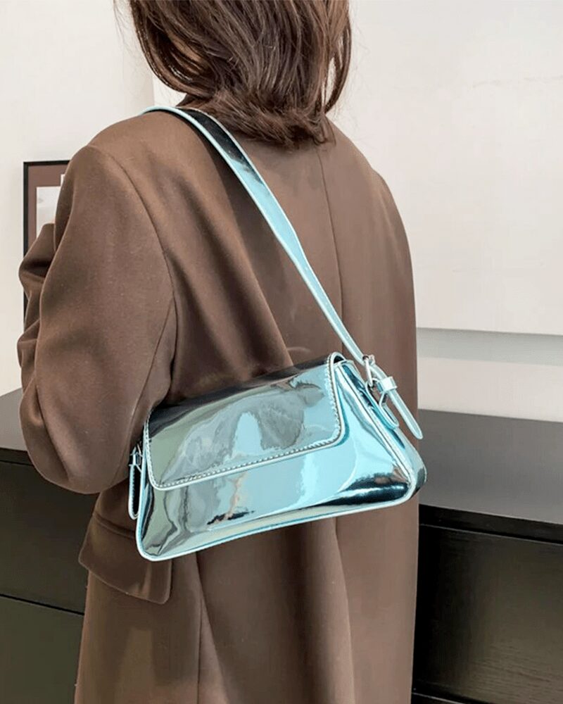 Affichez votre goût sophistiqué avec le sac à main Molly en vernis bleu, un choix élégant porté à l'épaule, ajoutant une touche de couleur à votre allure.
