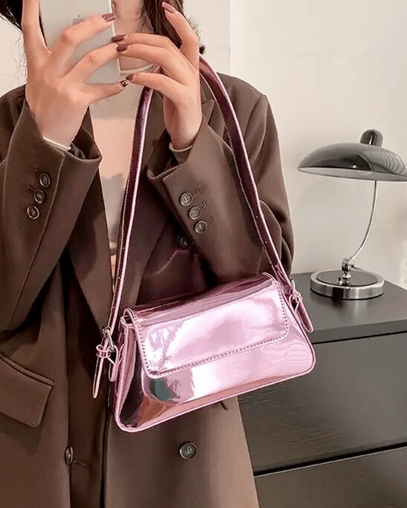 Faites ressortir votre côté féminin avec le sac à main Molly en vernis rose, une pièce délicate portée au bras, ajoutant une touche romantique à votre tenue.
