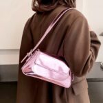 Célébrez la féminité avec le sac à main Molly en vernis rose, une pièce délicate et tendance portée gracieusement à l'épaule, ajoutant une touche de romantisme à votre style.