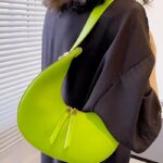 Femmes gracieuses portant le sac à main en similicuir vert Palma, ajoutant une touche de fraîcheur et d'élégance à leur tenue, porté confortablement sur l'épaule.