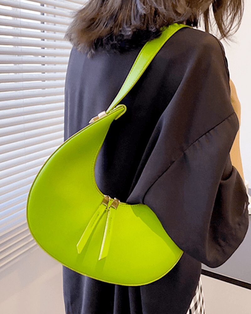Femmes gracieuses portant le sac à main en similicuir vert Palma, ajoutant une touche de fraîcheur et d'élégance à leur tenue, porté confortablement sur l'épaule.