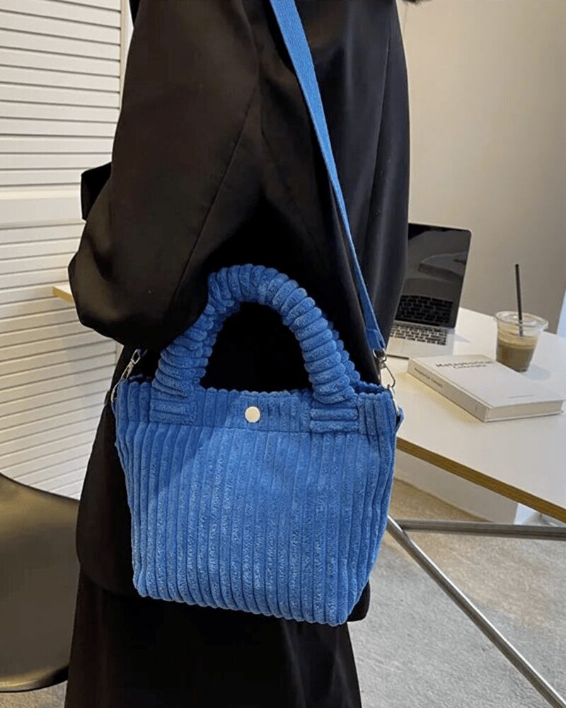 Découvrez le raffinement du Daisy Sac à Main Fourre-Tout en Velours Côtelé Bleu, une pièce incontournable portée avec élégance sur l'épaule, offrant un mélange parfait de style et de praticité.