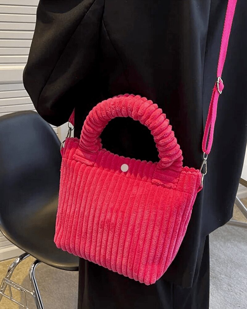 Le Daisy Sac à Main Fourre-Tout en Velours Côtelé Rose, un accessoire délicat qui incarne la féminité et le raffinement, parfaitement porté sur l'épaule.