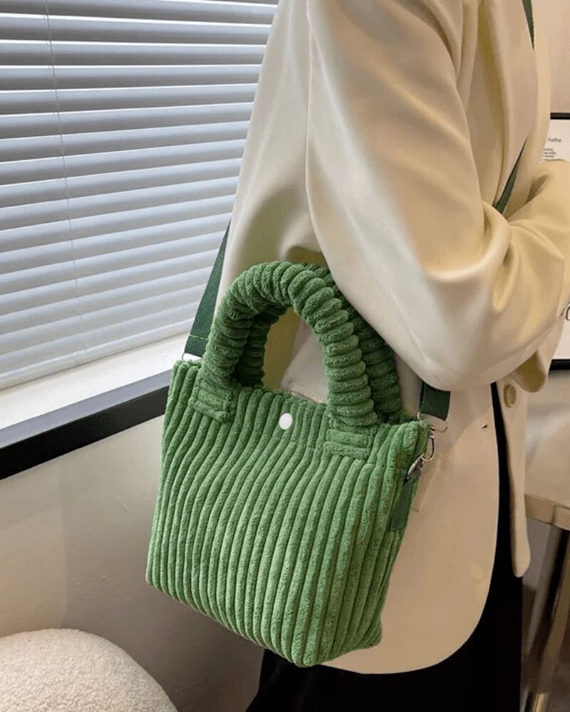 Élégance en Vert : Le Daisy Sac à Main Fourre-Tout en Velours Côtelé, une déclaration de style portée avec aisance en bandoulière par la femme moderne.