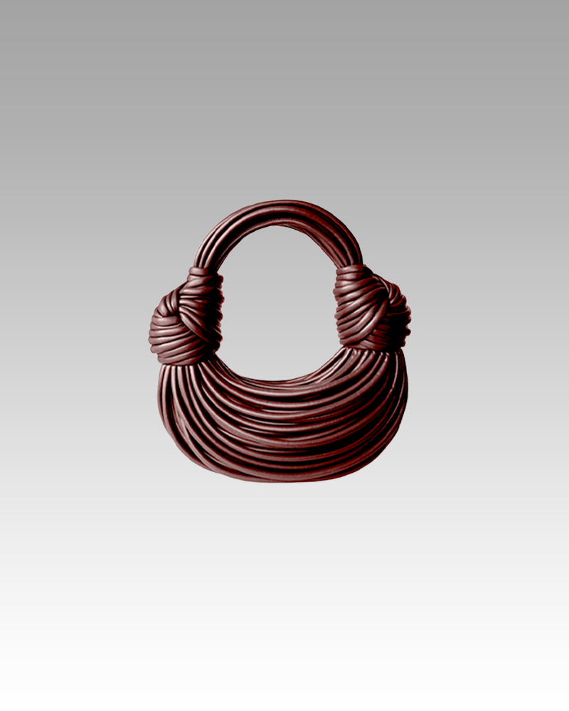 Sac à main Gaby tissé chocolat, porté par une femme dans la boutique Izamel.
