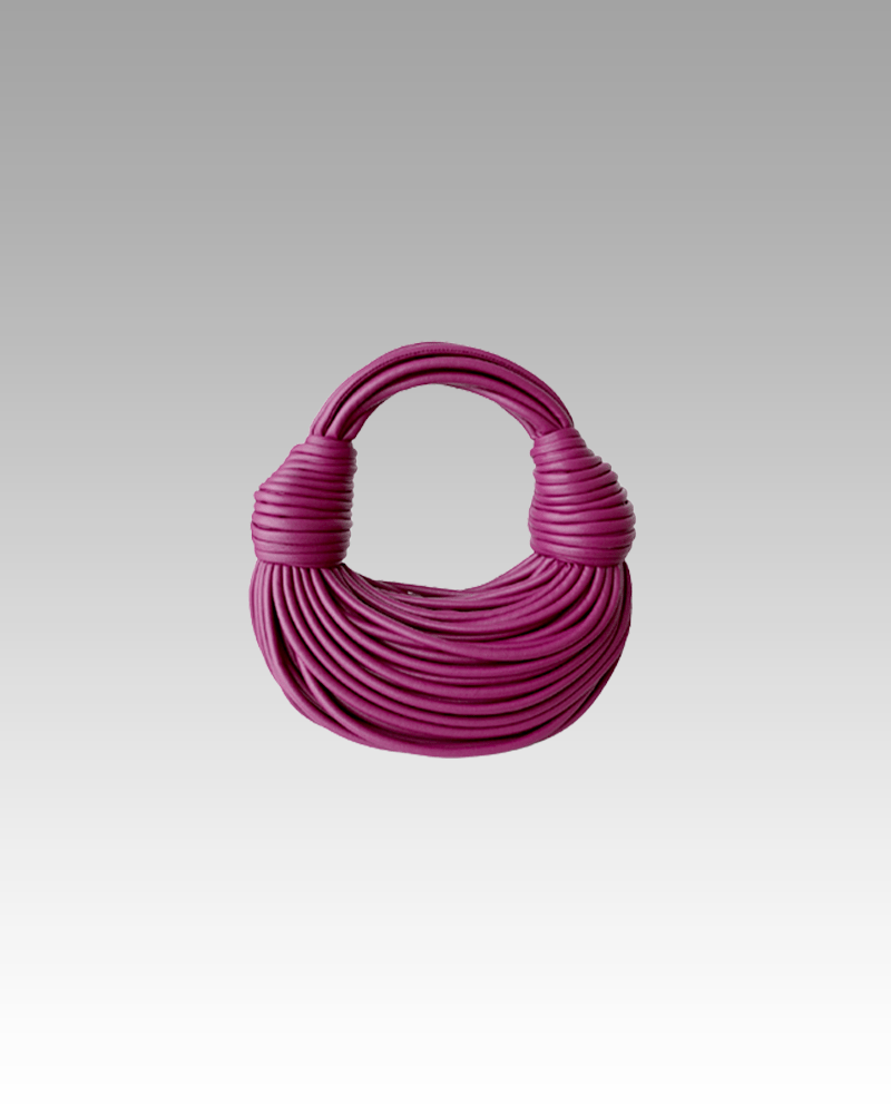 Sac à main Gaby tissé framboise, porté par une femme dans la boutique Izamel.