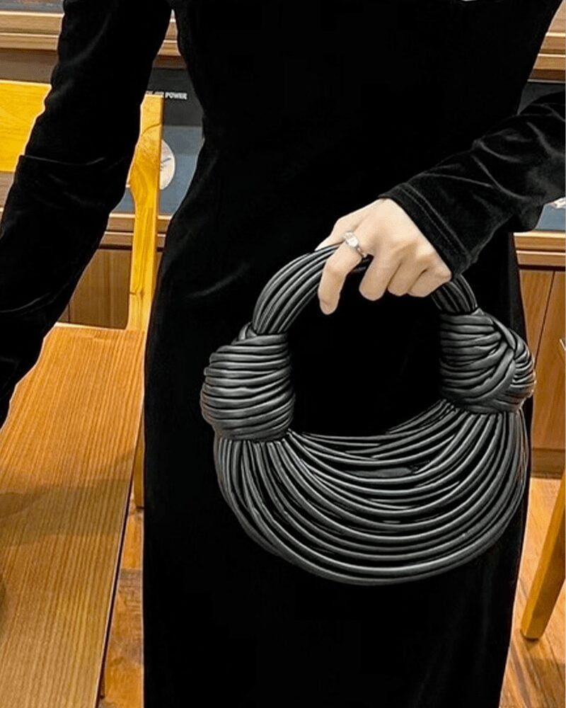 Sac à main Gaby tissé noir, tenu par une femme.