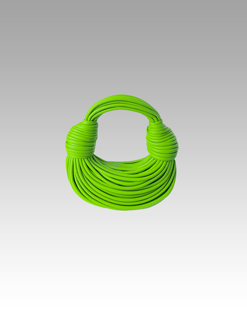 Sac à main Gaby tissé vert clair, porté par une femme dans la boutique Izamel.