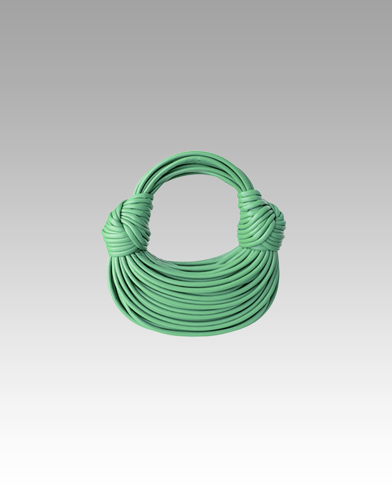 Sac à main Gaby tissé vert, porté par une femme dans la boutique Izamel.