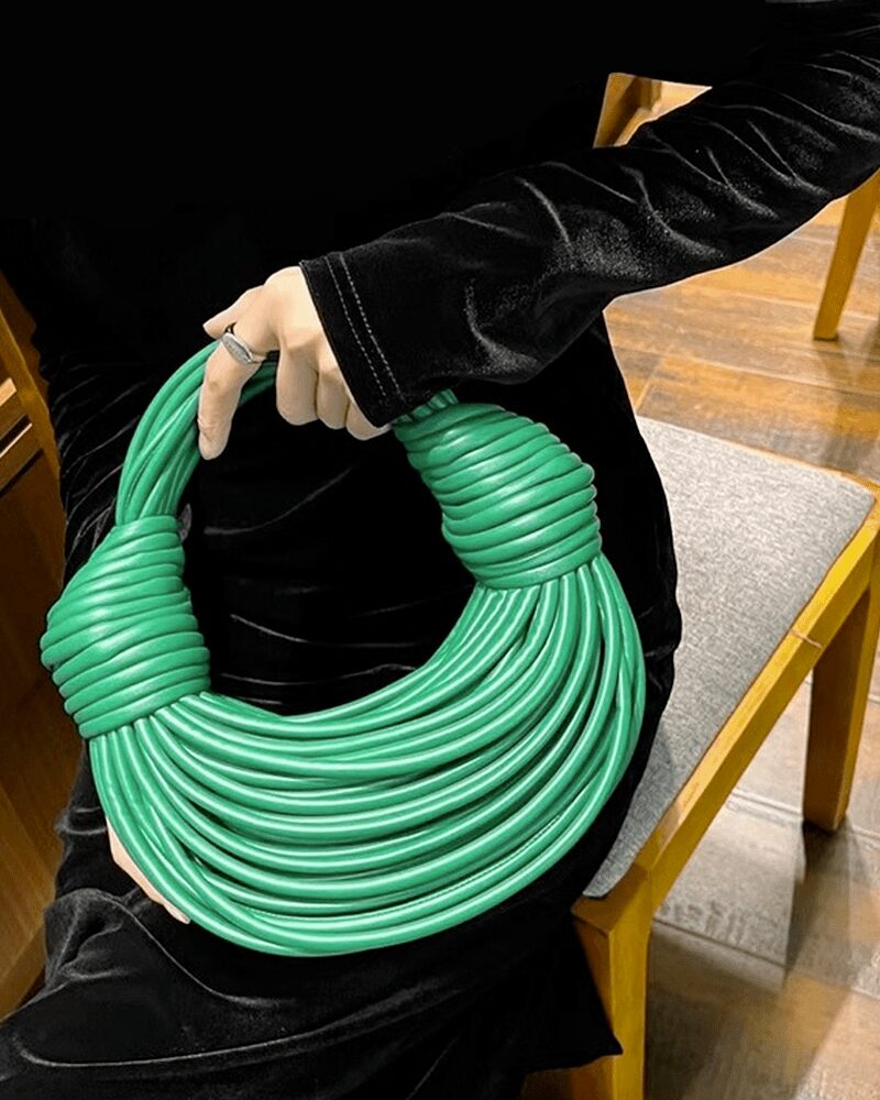 Sac à main Gaby tissé vert, porté par une femme.