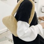 Sac à main crème Jamie en peluche, accessoire de mode pour femmes portant à l'épaule.