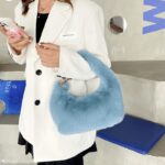 Sac à main Julie en fausse fourrure bleue - Accessoire tendance porté avec élégance par une femme.