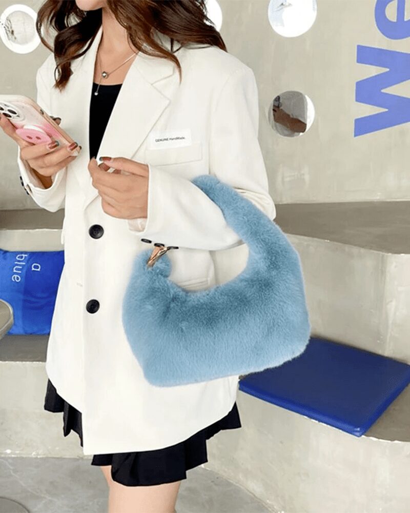 Sac à main Julie en fausse fourrure bleue - Accessoire tendance porté avec élégance par une femme.