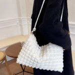 Explorez la sophistication sans effort de Kate, le sac à main fourre-tout blanc, porté avec chic sur l'épaule d'une femme, un choix incontournable pour les amatrices de style.