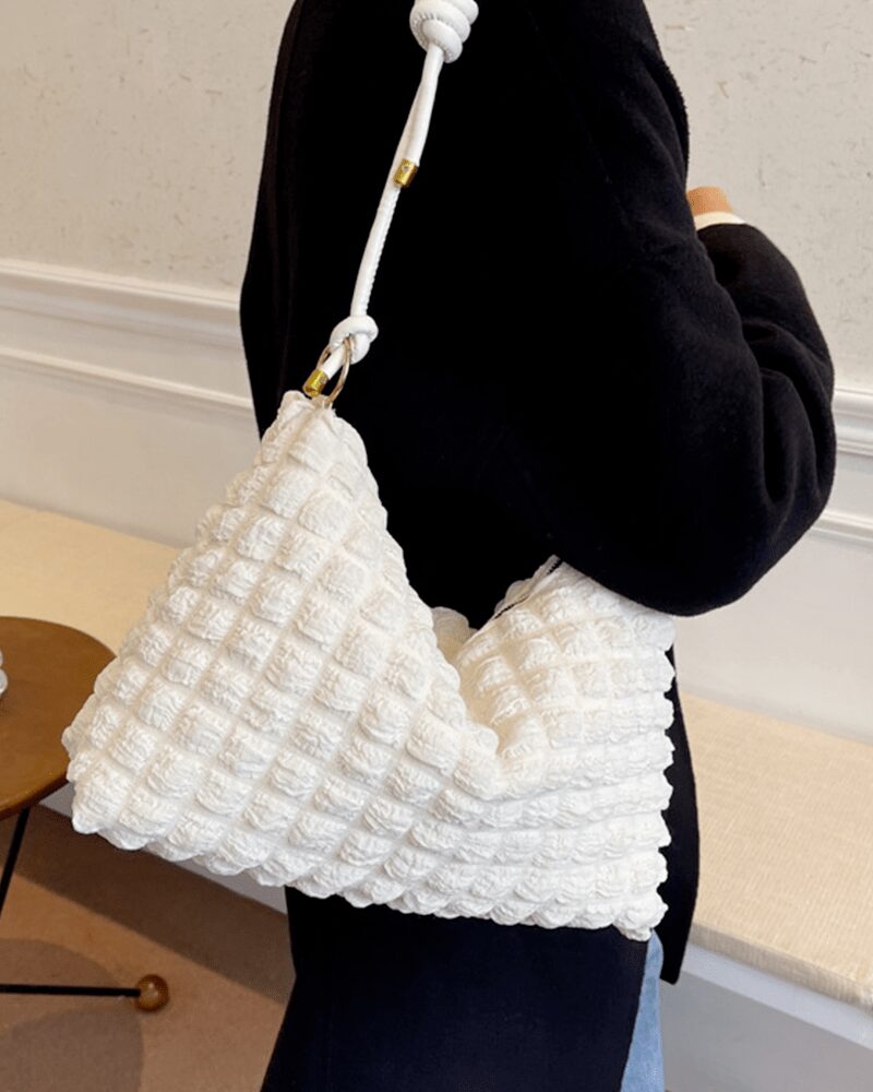 Découvrez l'élégance contemporaine de Kate, le sac à main fourre-tout blanc, magnifiquement porté sur l'épaule d'une femme, une déclaration de style raffinée.