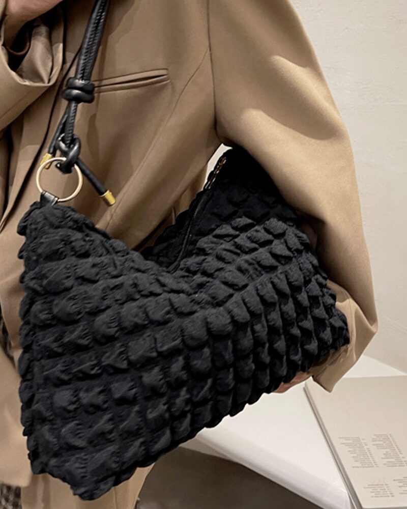 Découvrez l'exclusivité du sac à main fourre-tout noir Kate, une icône de la mode portée avec allure sur l'épaule d'une femme tendance.