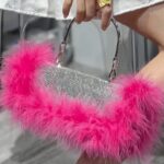 Sac à main Kylie rose avec strass et plumes, femme le tenant.