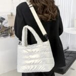 Femme portant le sac à main matelassé blanc Lara sur l'épaule.