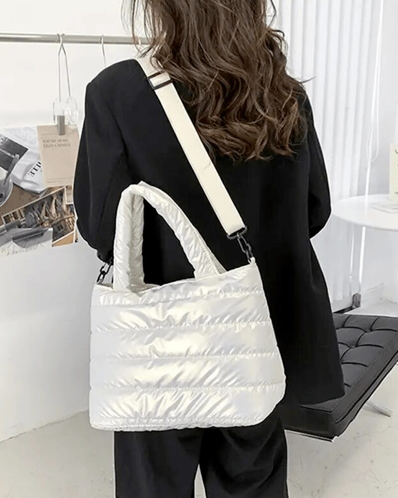 Femme portant le sac à main matelassé blanc Lara sur l'épaule.