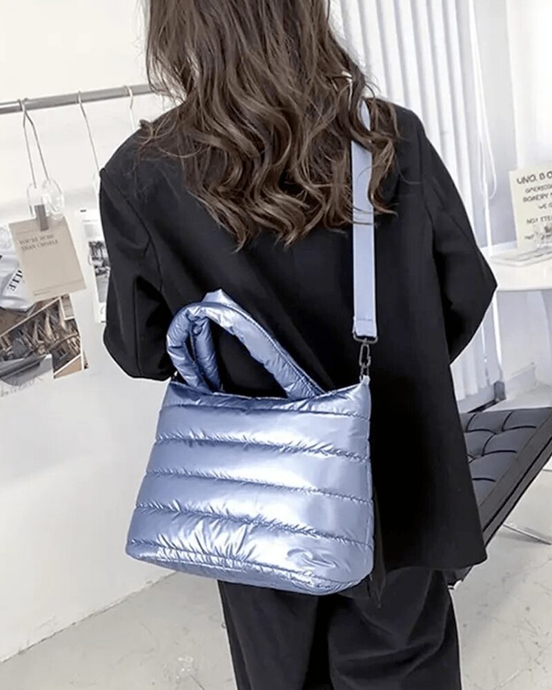 Femme portant le sac à main matelassé bleu Lara en bandoulière.