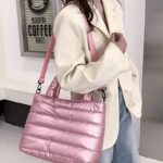 Femme portant un sac à main matelassé rose Lara sur l'épaule.