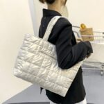 Femme arborant fièrement le sac à main matelassé blanc Méryl sur l'épaule.