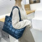 Femme arborant à l'épaule le sac à main matelassé bleu Meryl.