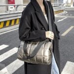 Femme portant le sac à main matelassé Nelly couleur champagne en bandoulière.