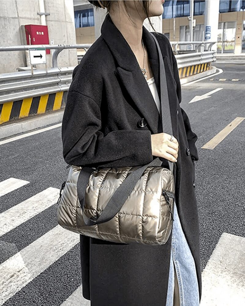 Femme portant le sac à main matelassé Nelly couleur champagne en bandoulière.