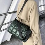 Sac à main matelassé vert Nelly porté à l'épaule par une femme.