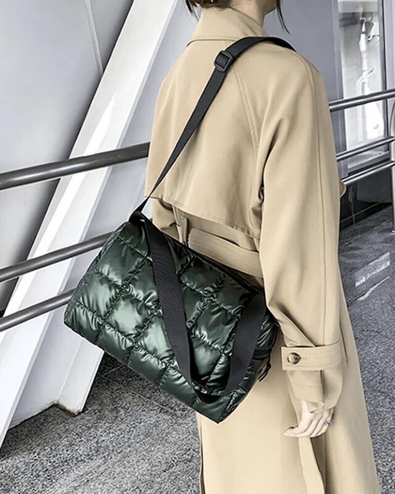 Sac à main matelassé vert Nelly porté à l'épaule par une femme.